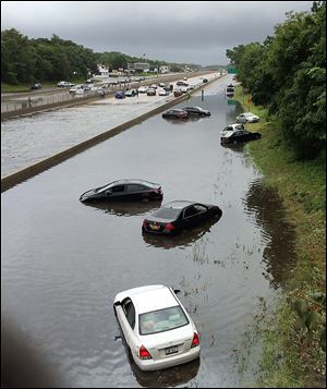 Vehicles are submerged on a flooded section of Sunrise Highway, in East Islip, N.Y., on New York's Long Island. Stranded Long Island drivers have been rescued after a storm slammed Islip, N.Y., with over 12 inches of rain — an entire summer's worth.