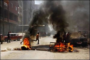 Egyptian supporters of ousted President Mohammed Morsi block a road by setting waste on fire in Matariya Square, Cairo, Egypt, today.