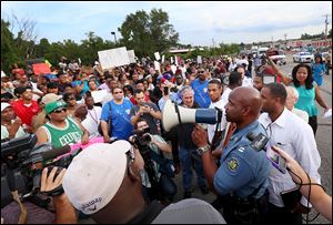 Missouri Highway Patrol Capt. Ronald Johnson addresses the crowd of protesters on Thursday, asking them to stay on the sidewalk and not block traffic.