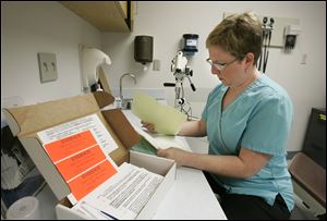 A nurse goes over paperwork from a rape kit in the emergency room at Mercy St. Vincent Medical Center.