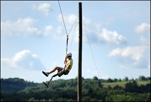 Cody Kenyon, 15, of Toledo rides on a zip line during the final full day of Camp STAR.