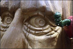 At left, a worm comes out of an apple on one of the tree sculptures created for the branch’s new children’s section. 