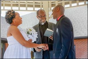 The Rev. Robert Davis, the father of the groom, conducts the marriage ceremony Saturday between Miriam Reeves and Mark Davis.