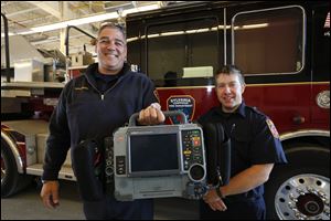 Sylvania Township firefighter/paramedics Greg Wilcox, left, and David Shutters display a LifePak 15 monitor/defibrillator at Fire Station No. 4 in Sylvania Township.