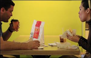 Carlos Gonzalez and Elsa Guzman eat breakfast at a McDonald's restaurant, in New York.