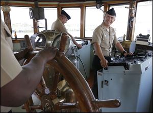 MMF Bryce Hannah, right, and his USS Toledo shipmates tour the wheel house of the Col. James Schoonmaker museum ship docked in Toledo.