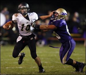 Perrysburg QB Gus Dimmerling runs past Maumee’s Dakota Yeary. Dimmerling threw for 1,688 yards and ran for another 1,207 yards with 15 TDs last season.