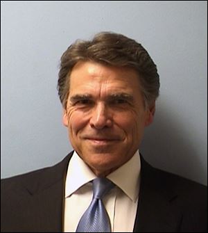 Texas Gov. Rick Perry smiles while being booked at the Blackwell-Thurman Criminal Justice Center in Austin, Texas, for two felony indictments of abuse of power on Tuesday.