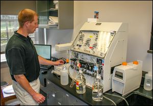 Inside the water quality laboratory of OSU’s Stone Laboratory, Justin Chaffin, the lab’s research coordinator, measures phosphorus and other nutrients found in the water.