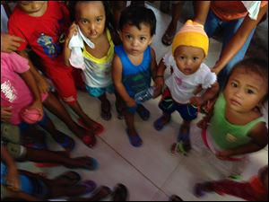 Tugbong children showing their new flip flops received from Father Stripe and Mr. Hoover.