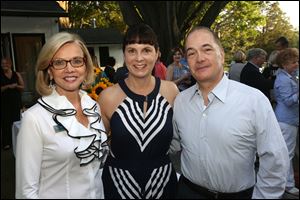 Chairman of the University of Toledo Women and Philanthropy Marianne Ballas, left, stands with Susan and Allan Block at their home. The Blocks hosted a dinner for the group, of which Mrs. Block is a member. 
