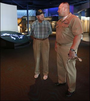 Pete Petersen, left, talks to USS Toledo Commander Mike Majewski while touring the National Museum of Great Lakes in Toledo.