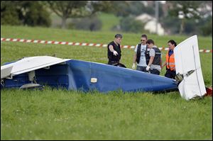 Police inspect the wreckage of a small plane that collided with another plane and crashed during an  emergency landing Sunday near Moerikon, Switzerland.