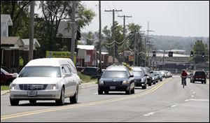 The funeral procession for Michael Brown drives through Wellston, Mo. 