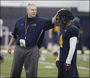 Jon Heacock, University of Toledo football team's assistant head coach/defensive coordinator/safeties coach talks to Corey Jones, during spring practice. 