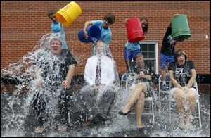 Left to right Father, Jeff Walker, associate pastor at St. Rose Church in Perrysburg,  St. Rose School Principal Bryon Borgelt, Assistant Principal Keri Struckholz, and Administrative Assistant Kathleen Schramm have ice water dumped on them for the ALS Ice Bucket Challenge by eighth graders in back (left to right) Carter Higgins, 13, Justin Batdors, 13, Emily Spackey, 13, and seventh grader Noah Zak, 13.