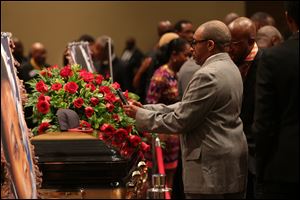 Director Spike Lee takes a picture of a black St. Louis Cardinals baseball cap on top of Michael Brown's casket during the funeral services at Friendly Temple Missionary Baptist Church in St. Louis.