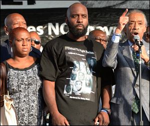 Reverend Al Sharpton, right, introduces the parents of slain teen Michael Brown, Lewsley McSpadden, left, and Michael Brown, Sr., center to the crowd at Peace Fest on Sunday in St. Louis.