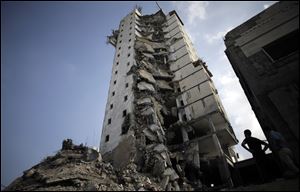 Palestinians inspect the damage to the Italian Complex following several late night Israeli airstrikes in Gaza City.