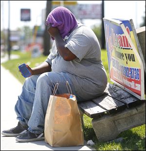 Jeremiah Bailey of Toledo covers his head with a towel in an attempt to block the heat while waiting for a bus along Secor Road. Forecasts for the rest of the week call for highs ranging from the upper 70s to mid 80s.