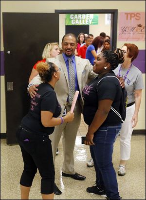 Romules Durant, superintendent of Toledo Public Schools, chats with junior Brittany Hacker, left, and senior Toshieyana Robinson, who are at Waite High School helping freshmen on their first day of classes Tuesday.