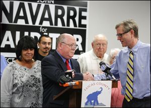 John Navarre shakes hands with Lucas County Republican Party Chairman Jon Stainbrook after announcing he is running for county auditor against his boss.
