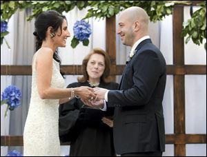 Boston Marathon bombing survivor, James Costello, right, marries Krista D’Agostino  at the hotel in Boston. Officiating is Carol Merletti, center. The couple met at Spaulding Rehabilitation Hospital where D’Agostino worked as a nurse and helped Costello recover from his burns and injuries.