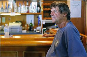 Richard Hamm, at the bar of his Scudder Beach Bar and Grill on Pelee Island, keeps calm about water quality concerns, even as a big tourism weekend approaches.