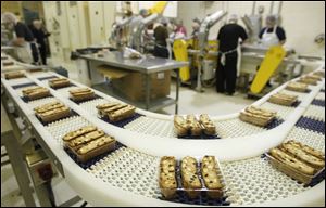 Packages of Almondina almond biscuits move along a conveyor belt at the YZ Enterprises Inc. cookie factory in Maumee.