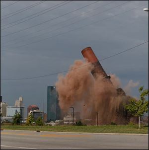 A portion of the last smokestack at the site of the former Toledo Edison Power Plant in East Toledo is imploded Friday. 