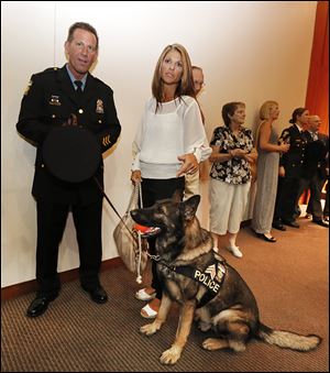 Toledo police Sgt. Joseph Taylor, his wife Amie, and Sgt. Joker attend a ceremony in which both sergeants were promoted.