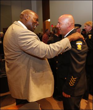 TPD Det. Perry Waddell, left, congratulates Capt. Ron Frederick upon his promotion. Det. Waddell also offered the invocation to the event. 