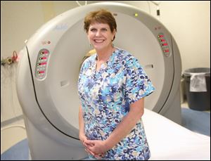 Chief CT technician Merrie Gilson stands near the CT scanner at ProMedica Flower Hospital.