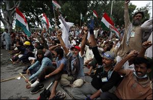 Supporters of anti-government Muslim cleric Tahir-ul-Qadri chant slogans as they stage a sit in protest close to Prime Minister's home in Islamabad, Pakistan today.