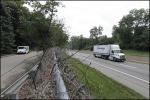 A USPS vehicle is parked in front of a home on Imperial Drive, left, a chain link fence across from westbound I-475.  The construction of noise walls is scheduled to begin this week. 