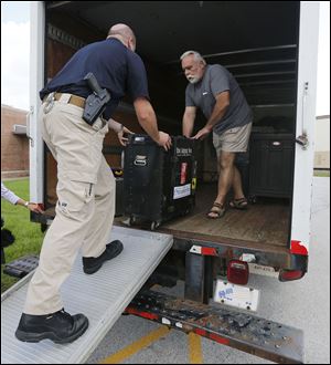Oregon Det. Ryan Spangler, left, and Tony Aringer load equipment into a van. The Euro Express Band had its equipment stolen Aug. 25.