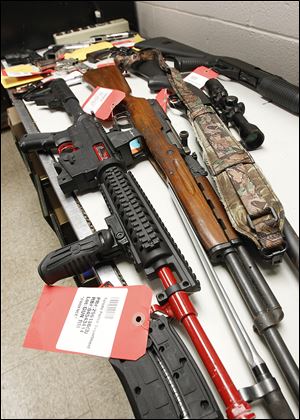 Eleven guns, including a modified AR-15 assault-style weapon confiscated from the Rev. Charles ‘Slim’ Lake, a street preacher, were displayed at the police department’s property room. 