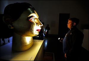 George Roush, 14, Whitehouse, views a painted and gilded fiberglass scupture by Indian artist Ravinder Reddy.
