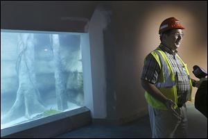 Jay Hemdal, Toledo Zoo curator of fishes and invertebrates, answers questions about the Flooded Amazon Forest exhibit tank as it is filled with water in the aquarium of the Toledo Zoo. 