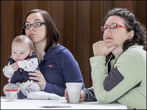 Heather Monnett and Maize, 4 months old, of Temperance, left, and Holly Miller of Toledo listen during the gathering at the Mothers’ Center of Greater Toledo.