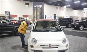 Cliff Ruggles of Marblehead, Ohio, looks at a 2015 Fiat on the first day of the show at the SeaGate Convention Centre.