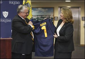 University of Toledo Board of Trustees Chairman Joseph H. Zerbey IV presents a personalized Rockets jersey to Sharon Gaber after introducing her as the new UT president, following a trustees meeting on Thursday. 