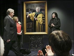 Dr. Lloyd Jacobs and wife, Ola, join artist Leslie Adams, right, in unveiling his portrait Thursday in a ceremony to rename the Lloyd A. Jacobs Interprofessional Immersive Simulation Center at the University of Toledo college of medicine and life sciences.