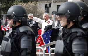 A man wearing a uniform representing the KKK shows where his sympathies lie at the National Socialist Movement rally in front of One Government Center.