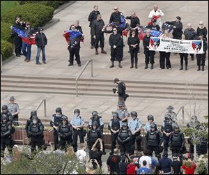 Members of the Toledo Police Department, many in riot gear, stand guard while the National Socialist Movement holds its rally.
