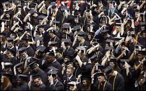Students move their tassels from right to left as they become alumni of Bowling Green State University. A total of 2,193 students turned their tassels at three ceremonies this weekend.