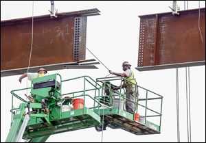 E.S. Wagner employees on Monday began positioning steel beams for new approach spans at the east end of Anthony Wayne Bridge.