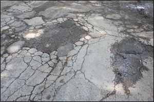 Patches to potholes are evident on Clover Lane. Many city residents say patches soon begin to disinegrate.