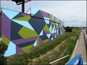 ‘Fort Industry,’ Toledo’s largest mural at 6,000 square feet, covers two sides of Toledo’s Parks Maintenance Building. The ‘dazzle camouflage’ pattern is based on a tactic used by the United States and Great Britain on battle ships during the World Wars.