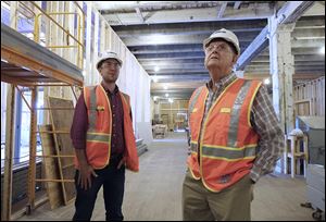 Patrick Stutler, a project engineer at Lathrop, left, and John Husman, Mud Hens team historian, take a look at the inside of the Fleetwood Building, 28 N. St. Clair St.